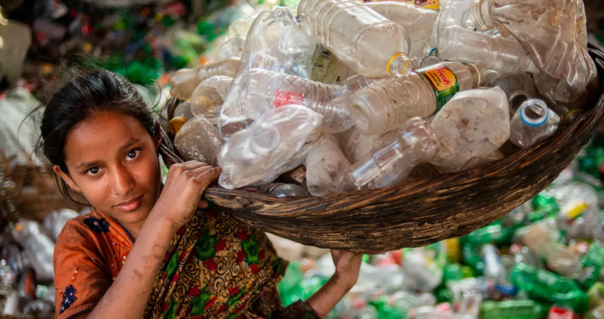 Fotografi ilustruese e një vajze që po mbledh shishe plastike.
