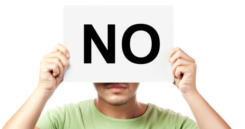 Fotografi ilustruese e një personi që ka në dorë një pankartë 'No'